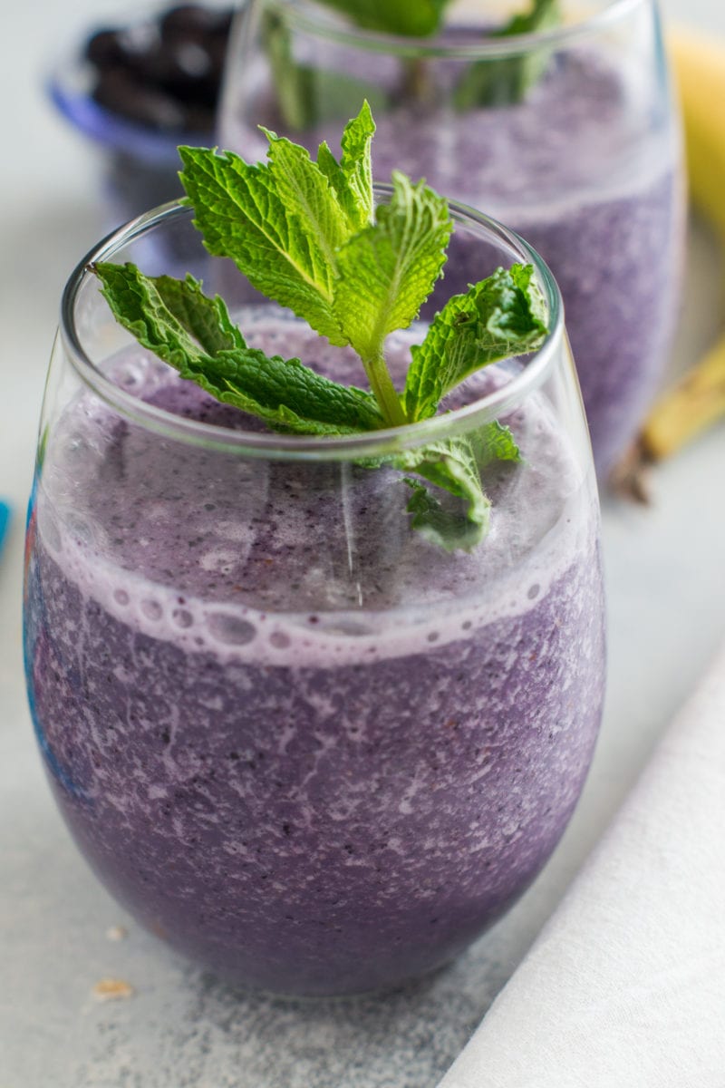 Close up of a fresh mint sprig in. blueberry smoothie.