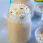 Pina colada dulce leche smoothie in a glass mason jar with a straw.