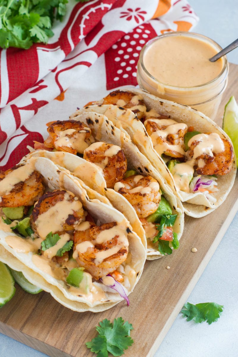 Three shrimp tacos drizzled with a chipotle sauce.