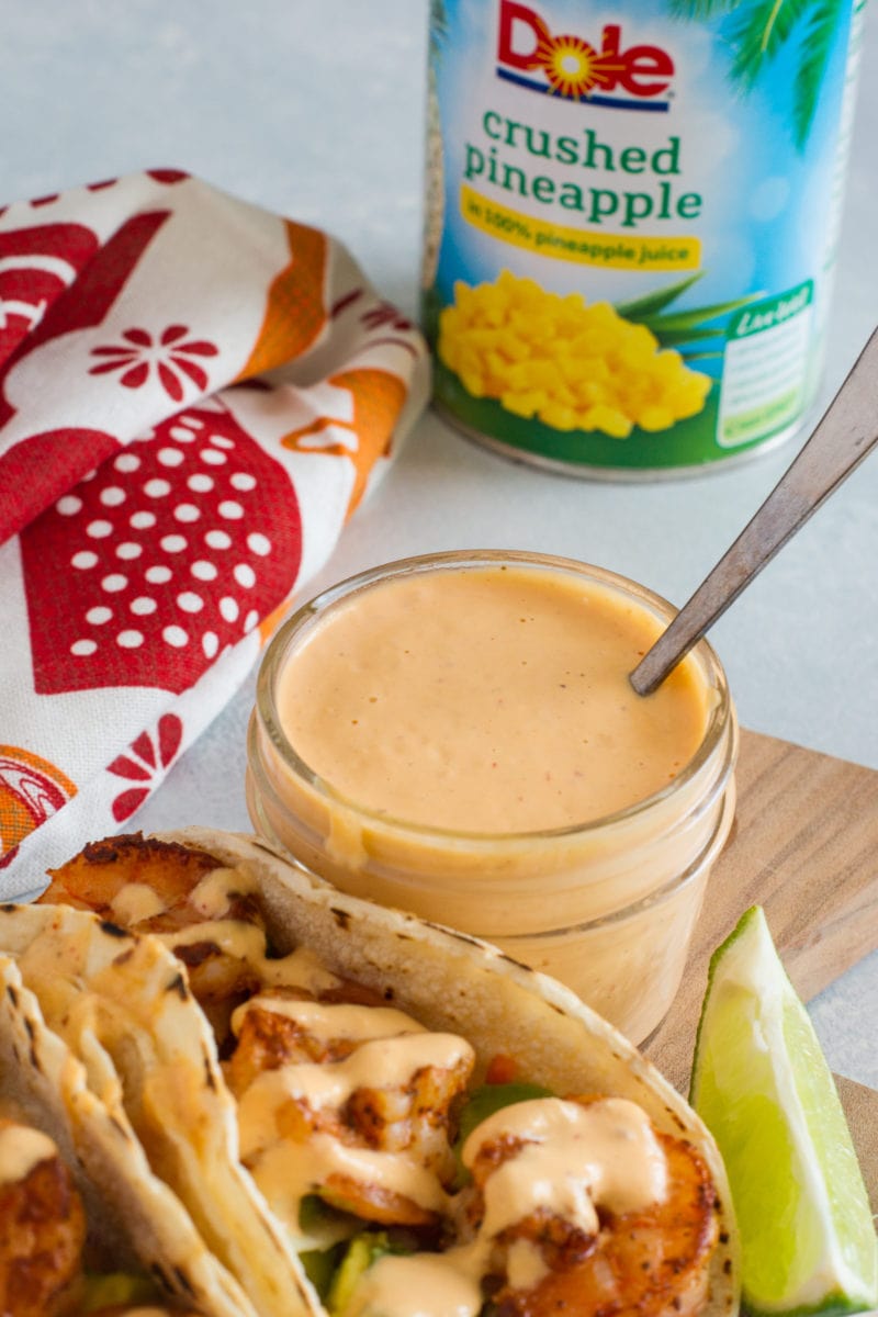 Close up of the pineapple chipotle sauce in a glass jar with a spoon.