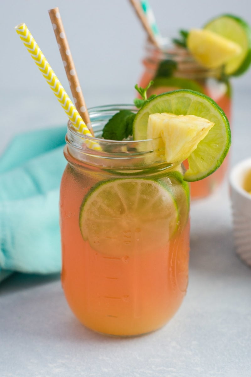 The mojito in a jar garnished with fresh pineapple, lime and mint.