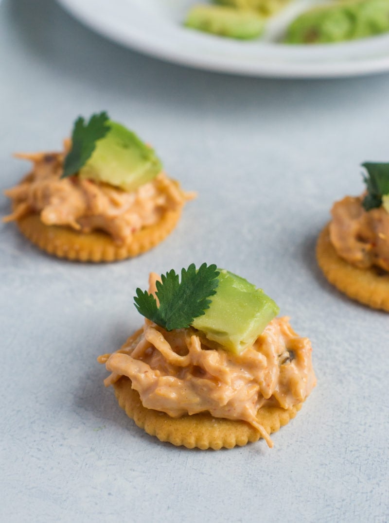 Ritz crackers topped with chicken nacho mix and avocado.