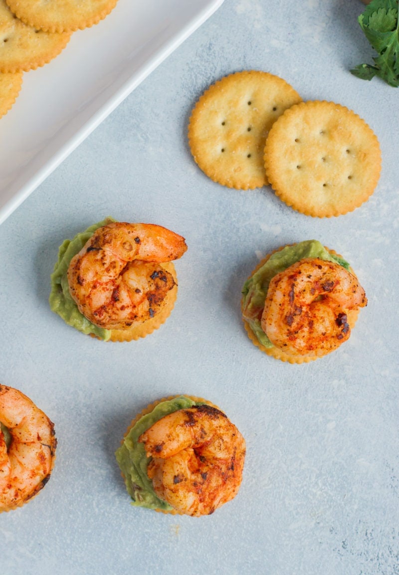 Overhead shot of four spicy shrimp and guacamole bites.