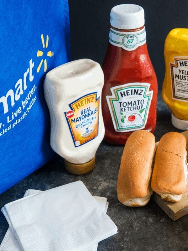 Hot dog buns and sauces next to a Walmart bag.