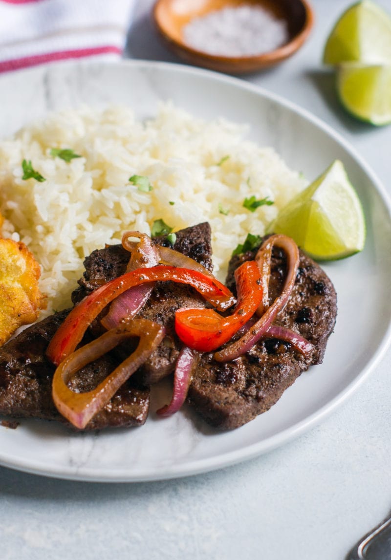 Close up of the cooked liver topped with red onions and strips of bell pepper.