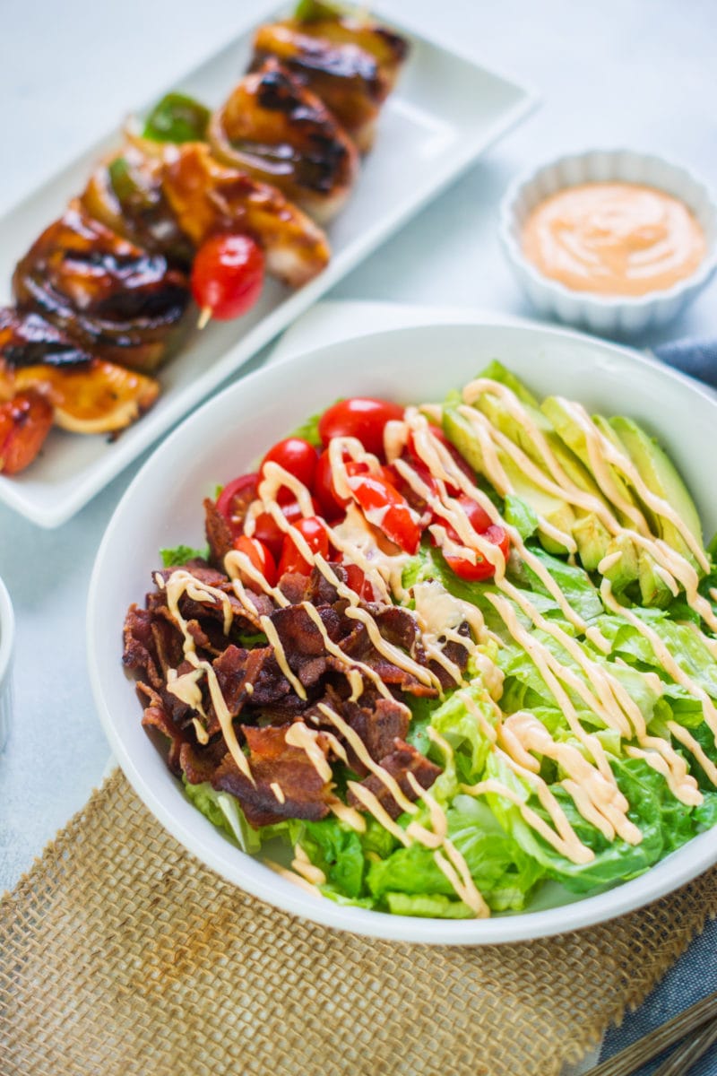 A BLT salad drizzled with sauce.