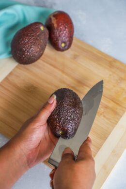 running the knife around the avocado lengthwise