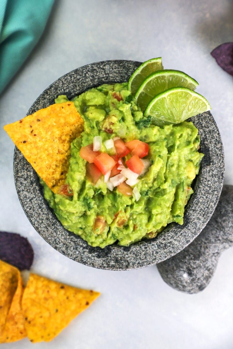 The Best Guacamole recipe served on a molcajete with corn chips on the side.