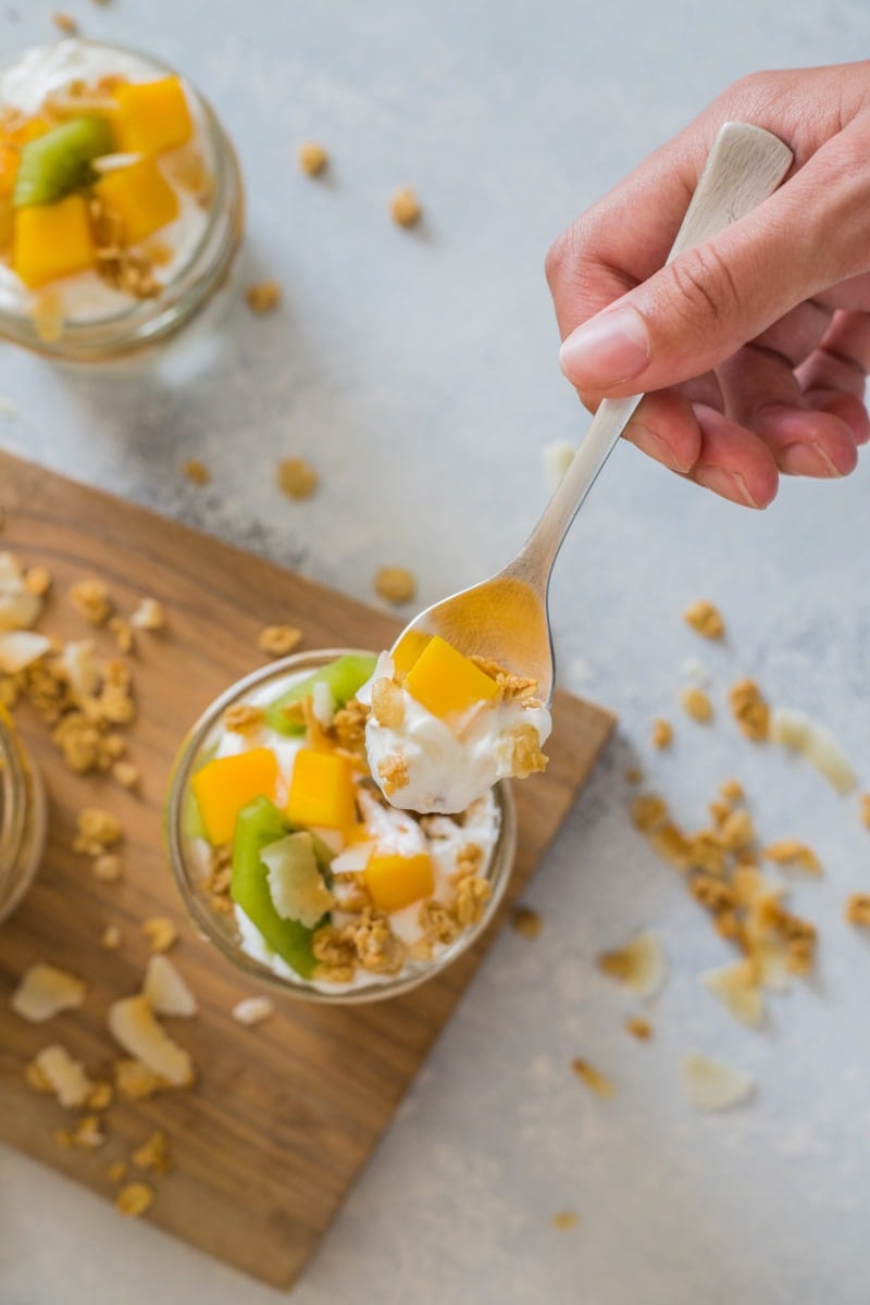 A parfait being eaten with a spoon.