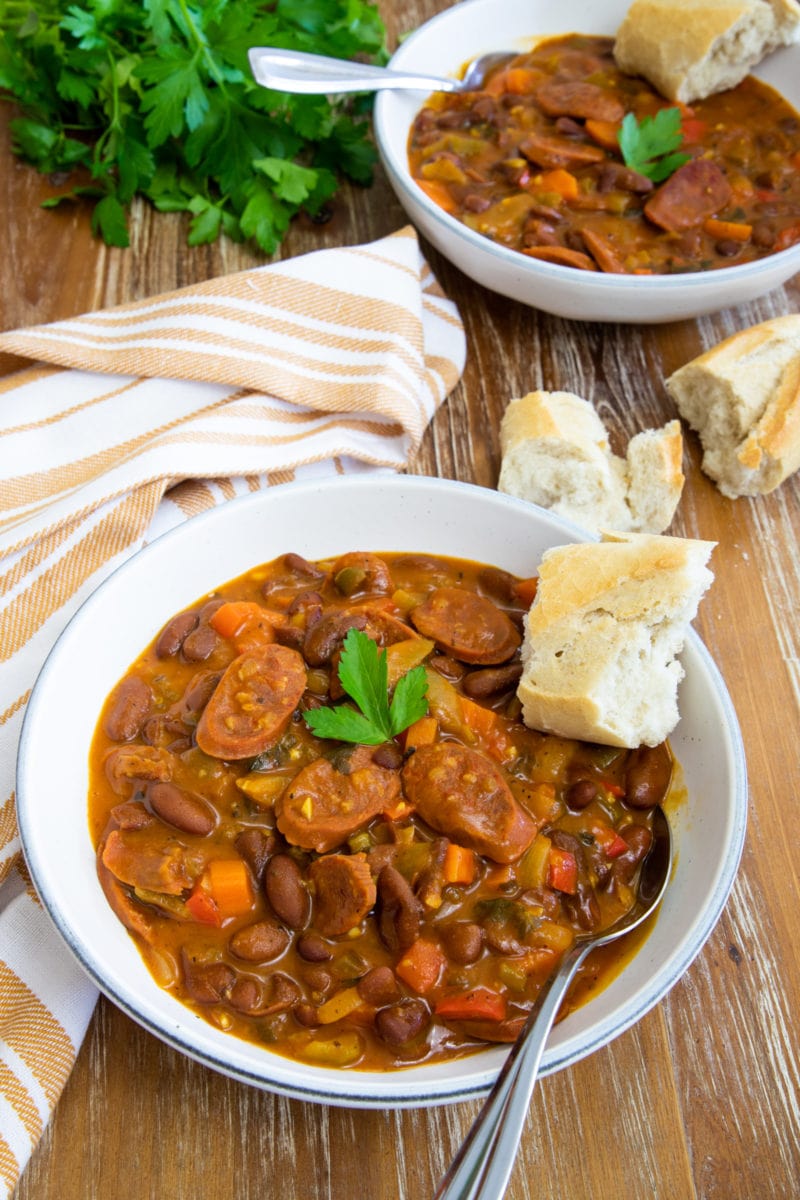 Chorizo and bean stew served in a bowl with crusty bread.