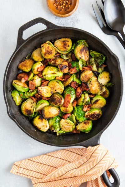 Sautéed Brussels sprouts and bacon in a cast iron skillet.
