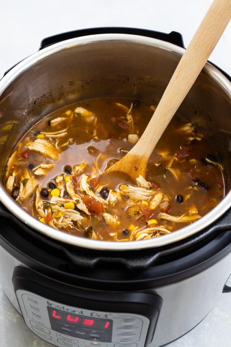 The soup in an Instant Pot with a wooden spoon.