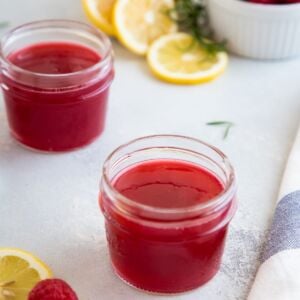 Raspberry simple syrup in two glass jars.