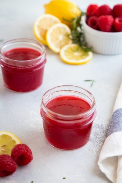 Raspberry simple syrup in two glass jars.
