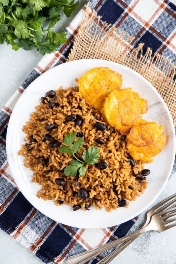 Black beans and rice on a plate garnished with fresh cilantro.