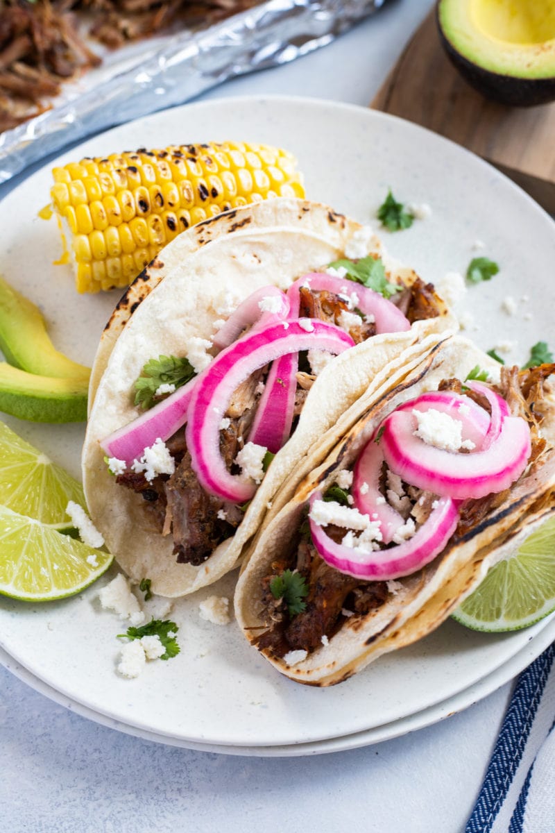 slow cooker carnitas tacos on a white plate