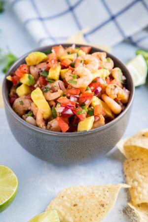 Spicy shrimp salsa served in a large bowl next to tortilla chips.