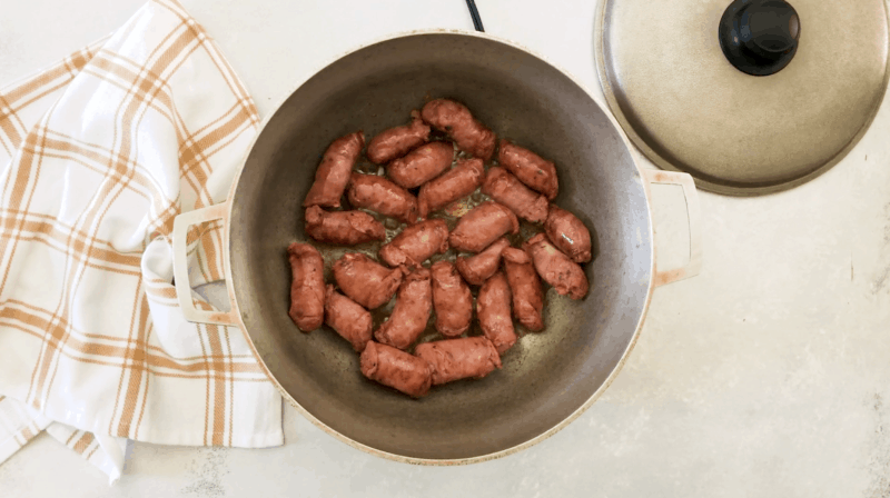 Sausage being cooked in a pan.