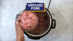 Ground pork being placed into the Instant Pot.