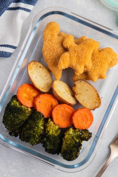 Yummy Dino Buddies with roasted vegetables on a glass food container
