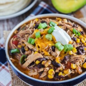 Slow cooker taco chicken chili in a blue and white bowl with toppings