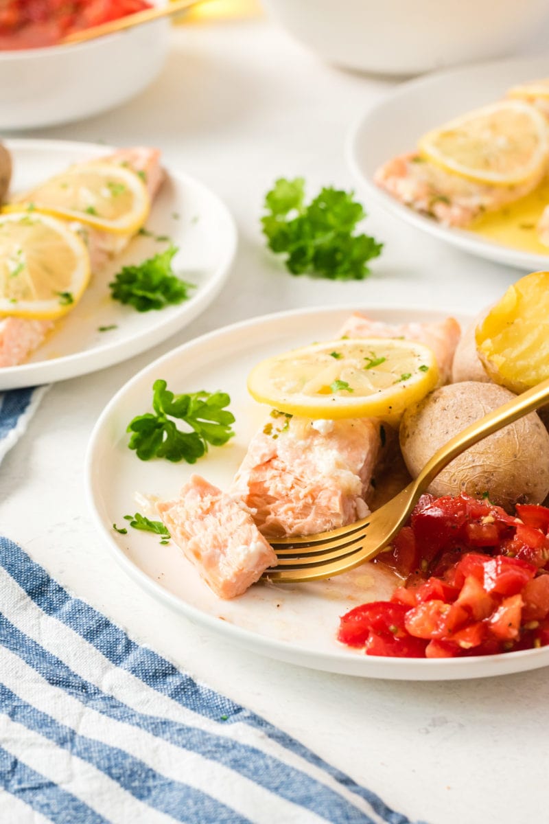 Un tenedor cortando un trozo de salmón.