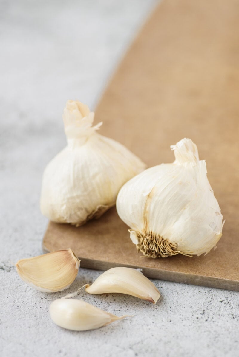 Bulbos de ajo y clavo en una tabla de madera