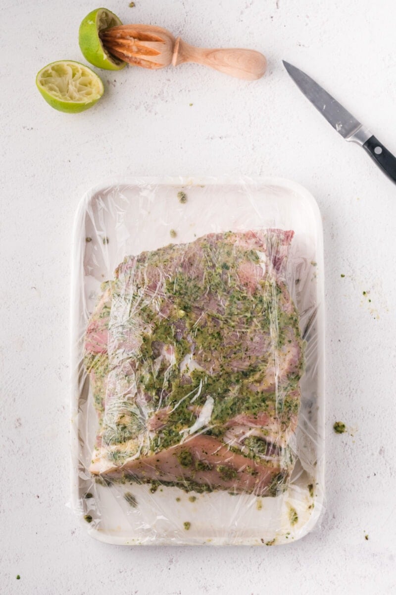 La carne de cerdo sazonada cubierta con film transparente.