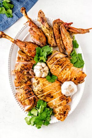Top down shot of a carved roasted turkey on a white platter.