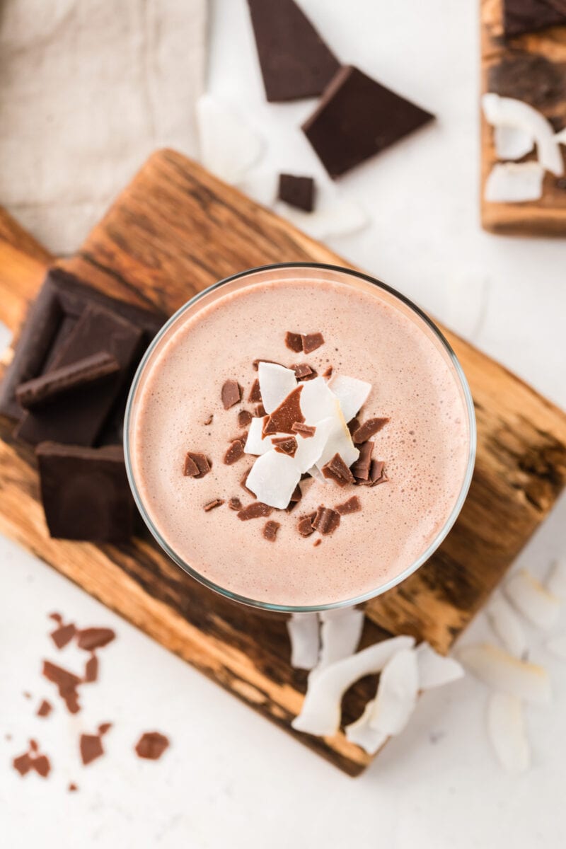 Overhead shot of a glass of chocolate coquito garnished with chocolate.