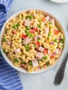 Overhead shot of macaroni served in a large bowl next to a serving spoon.