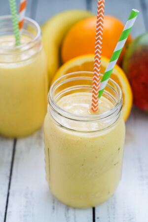 Mango Banana Smoothie served in a mason jar with paper straws