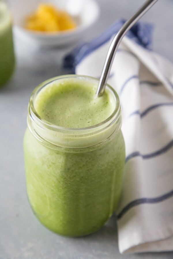 Pineapple and Spinach Smoothie served with a straw