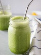 Pineapple Spinach Smoothie in a mason jar with silver straw