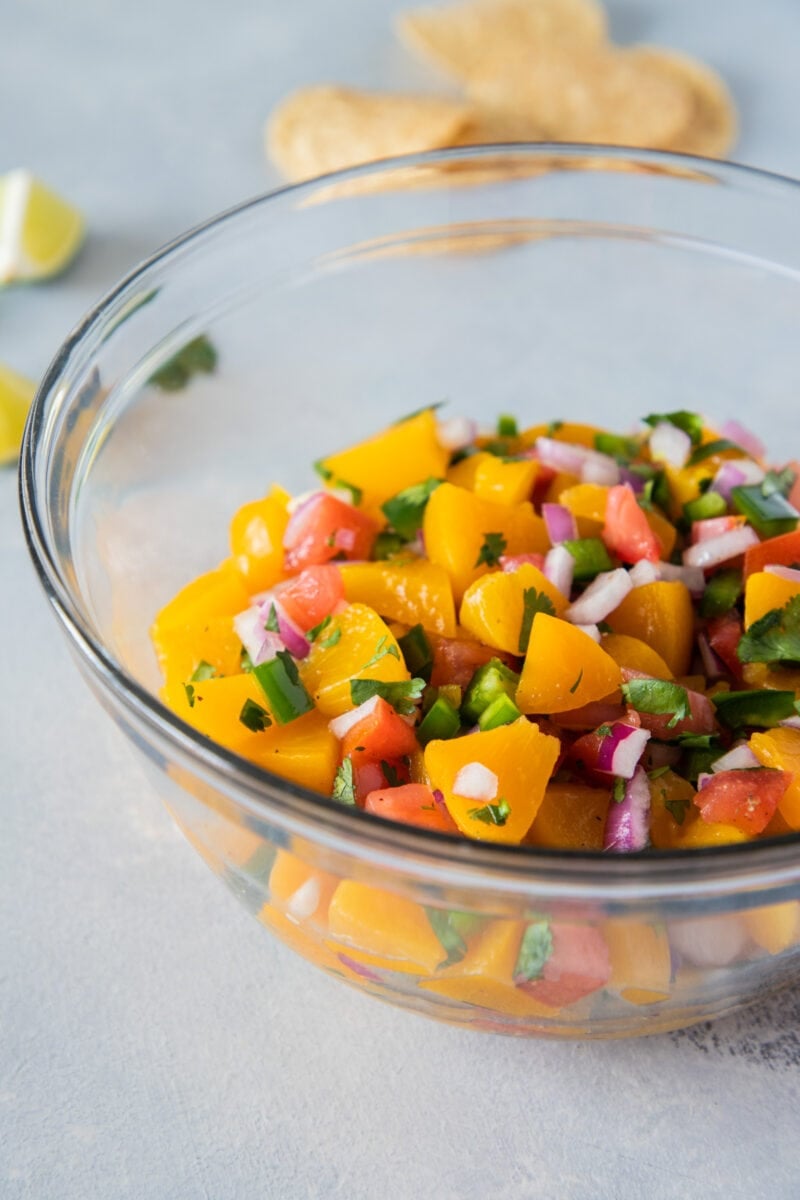 close up of peach salsa in a clear bowl ready to eat