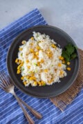 Rice with corn served on a gray plate ready to eat