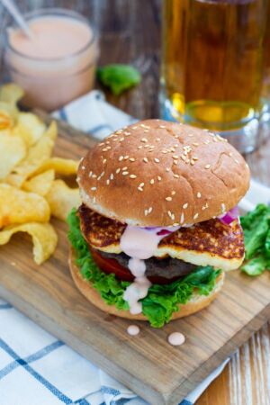 A burger in a bun with lettuce and tomato.