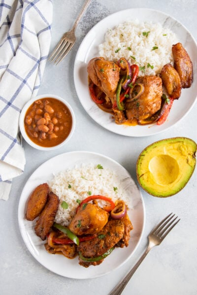 Dominican Food La Bandera - Pollo guisado, white rice and beans with avocado on the side