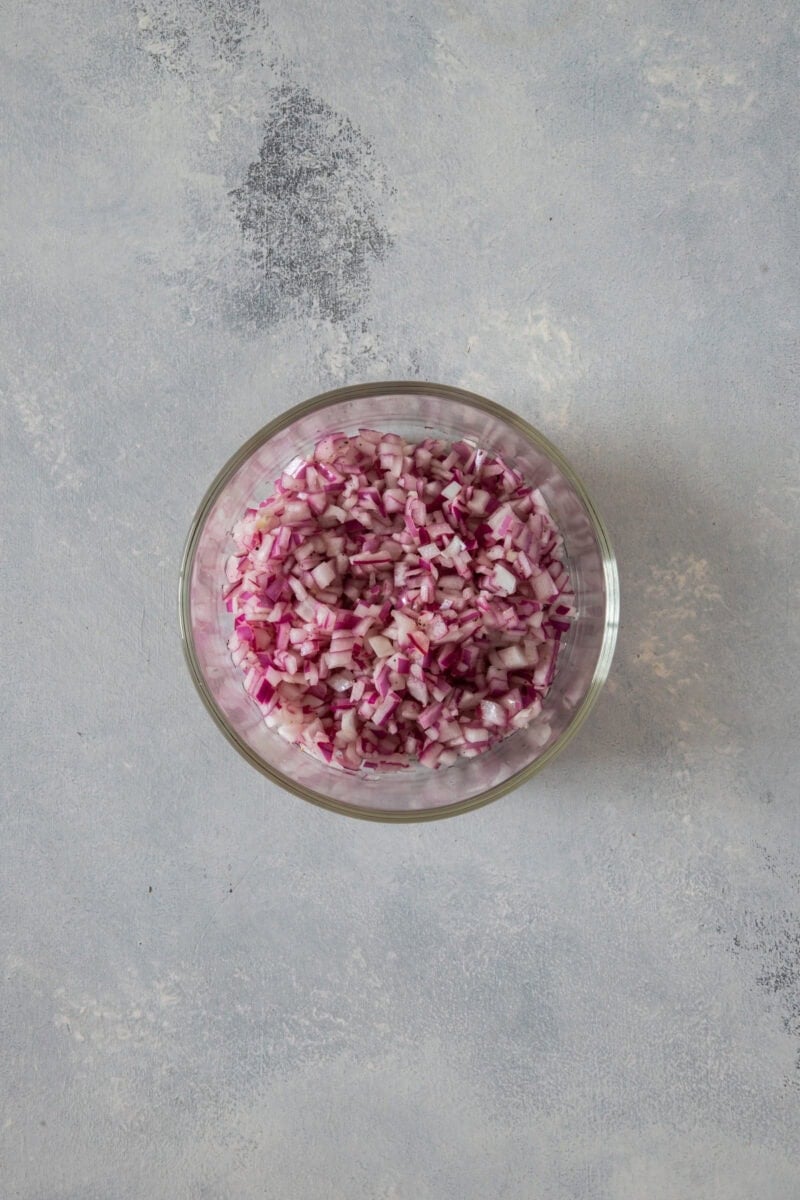 chopped pickeld onions in a clear bowl
