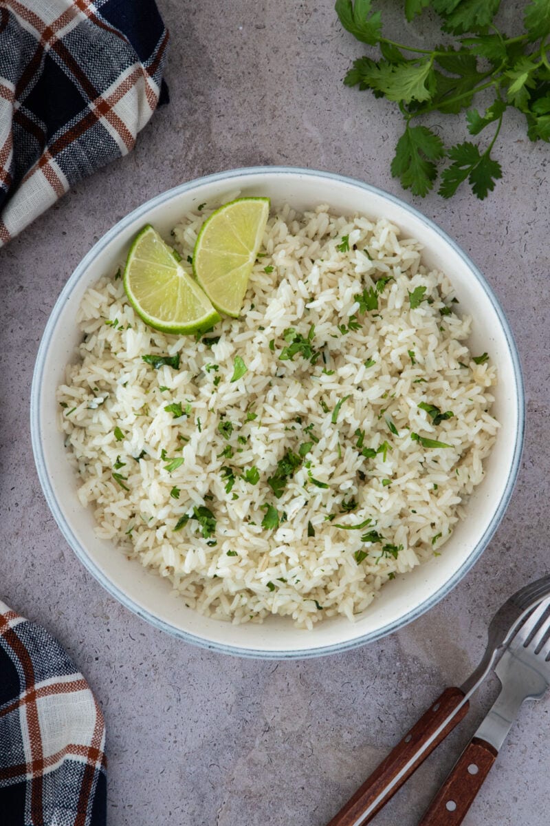 Cilantro rice served in a bowl with lime wedges on the side ready to eat