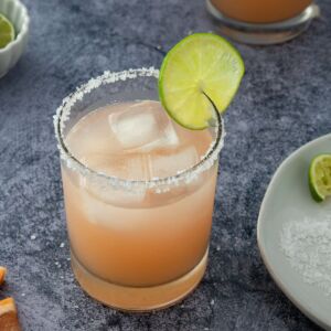 grapefruit margarita served in a glass with salt in the rim and a lime wedge