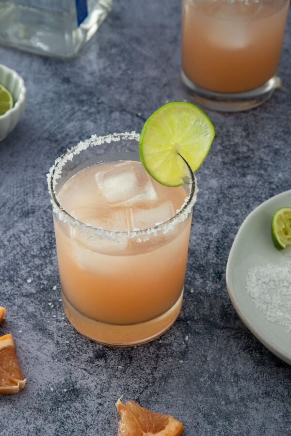 grapefruit margarita served in a glass with salt in the rim and a lime wedge