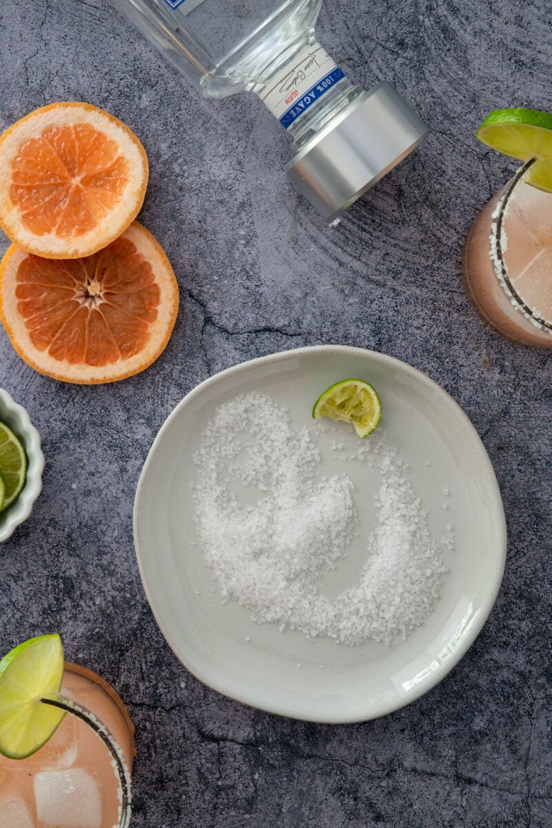 plate with salt and lime wedges and tequila for margarita cocktail