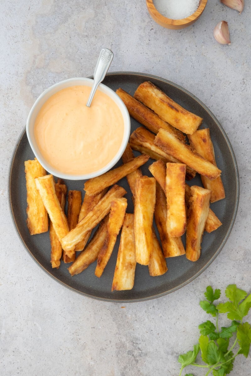 Yuca fries in a plate with spicy aioli on the side