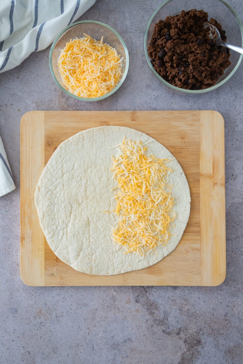 adding cheese to the tortilla