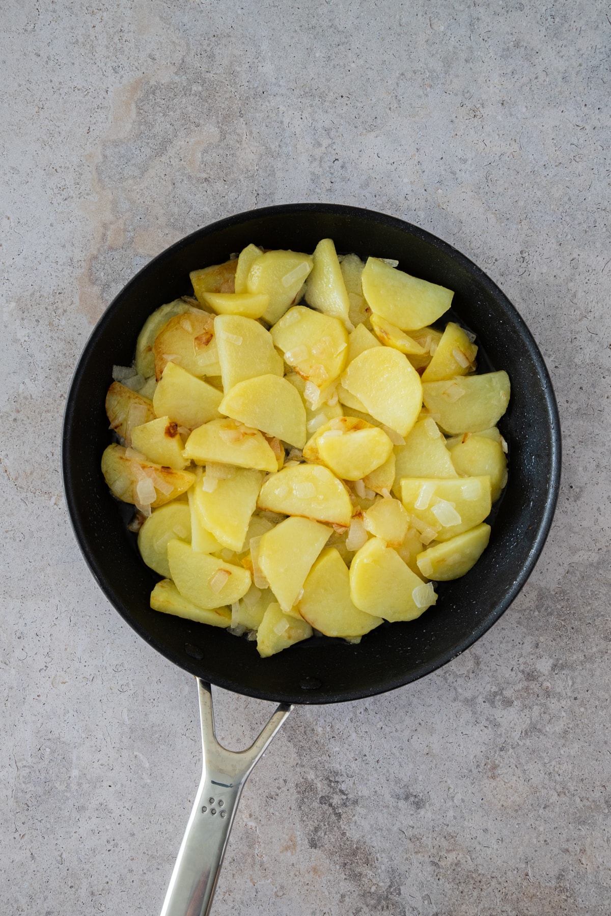 cooked potatoes and onions in the pan