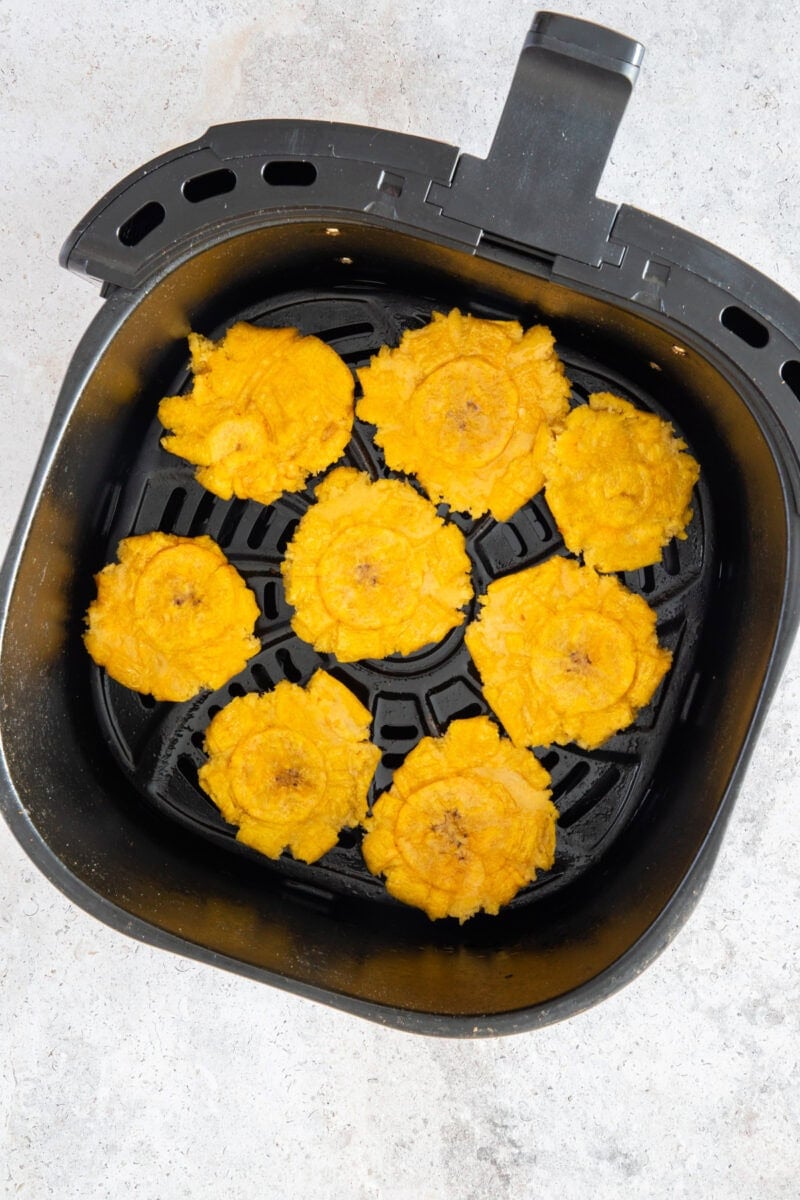 Once perfectly flattened, the plantain slices return to the air fryer for a second round of cooking. 