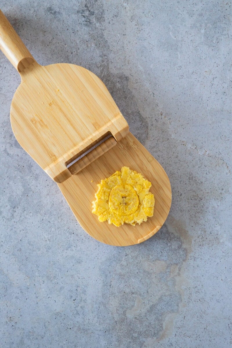 After the first fry, the plantain slices are gently pressed to create their classic shape. This step is key to achieving the perfect balance of a crispy exterior and a soft, tender interior that makes tostones so irresistible.