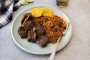 Plate of Dominican stewed goat served with moro rice and fried tostones.