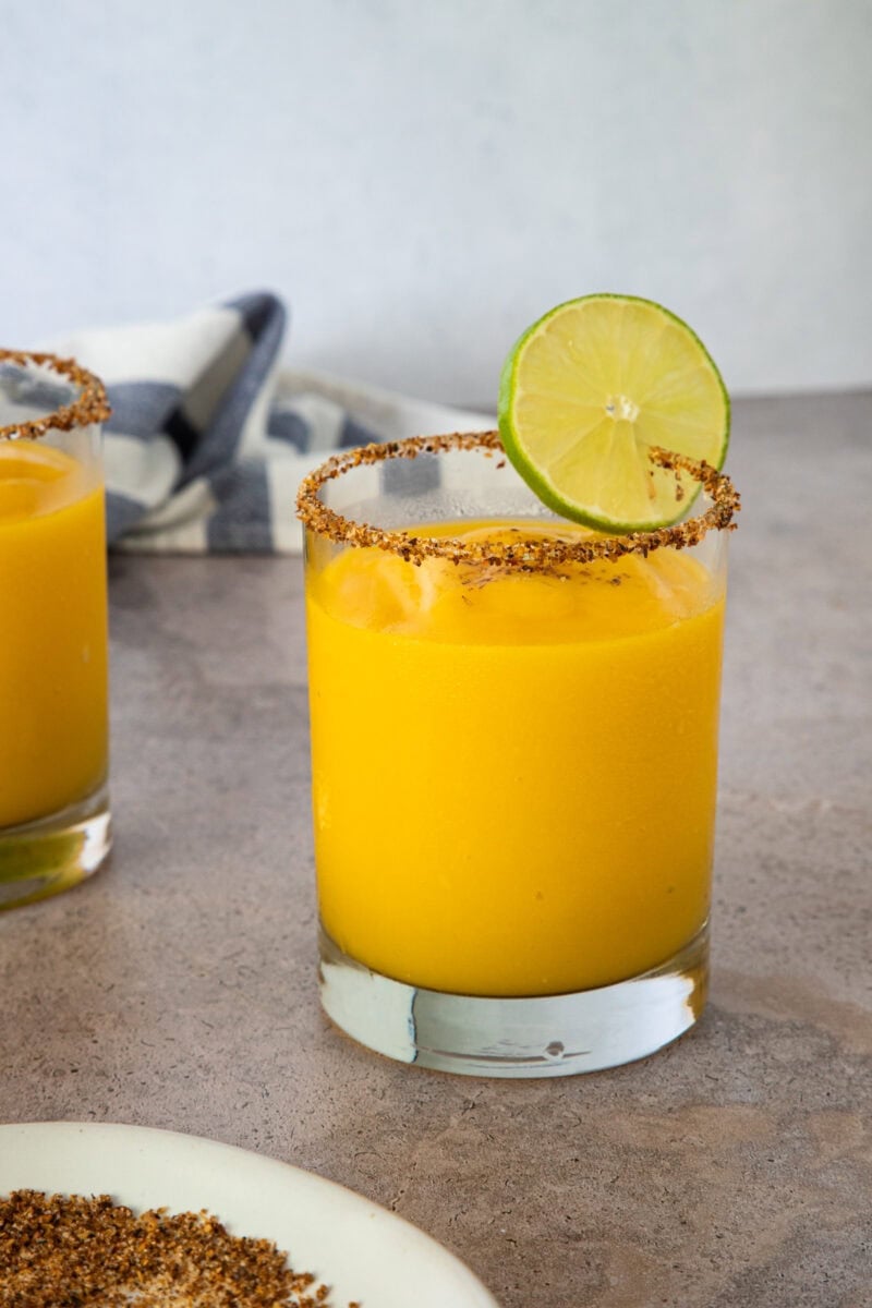 Frozen mango margarita with a chili-salt rim and lime slice garnish.